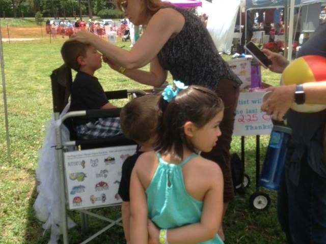 A child getting his face painted at the Colorado Springs Family Friendly Beer Festival.